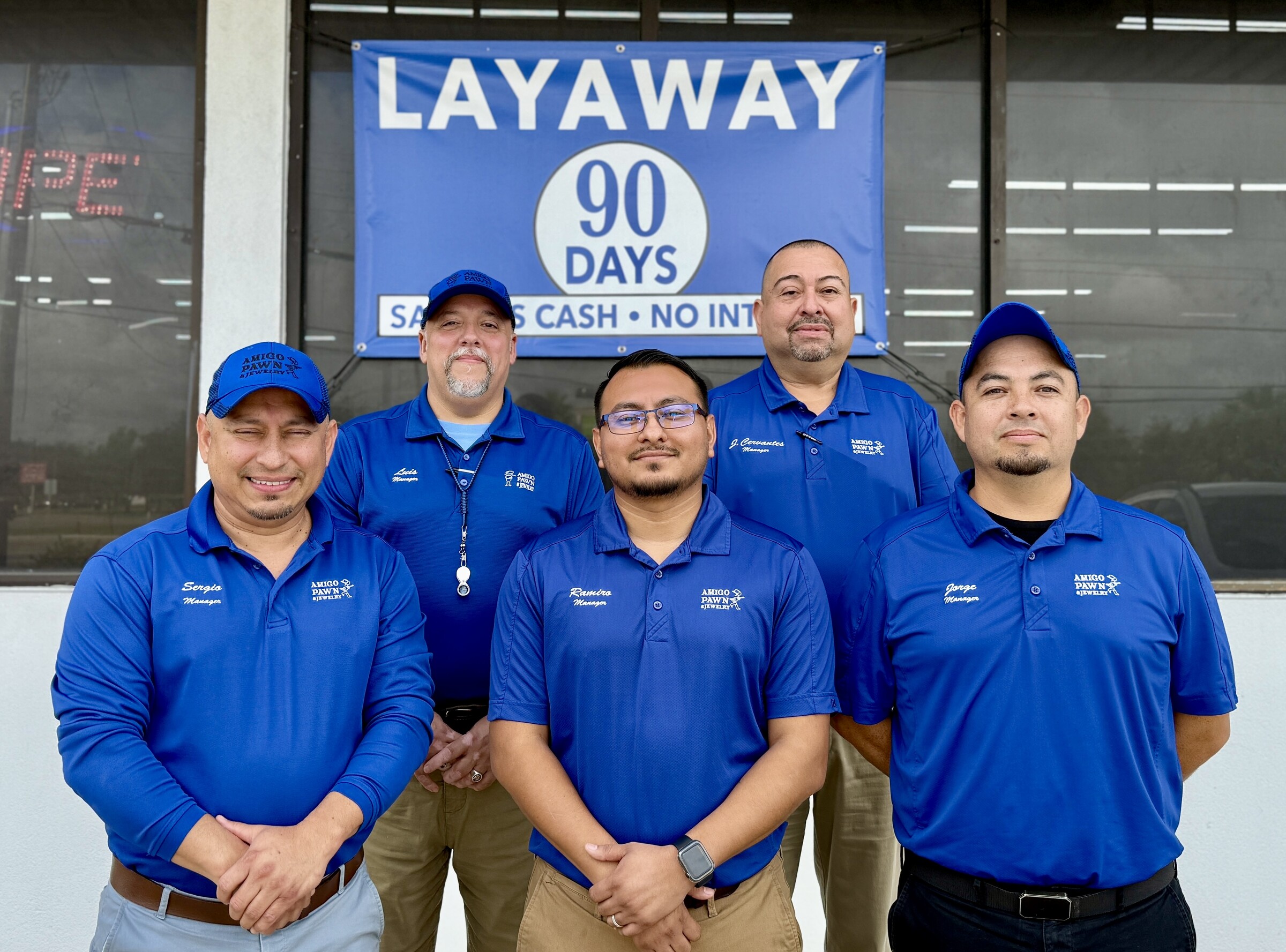 Five Amigo managers posing outside a store