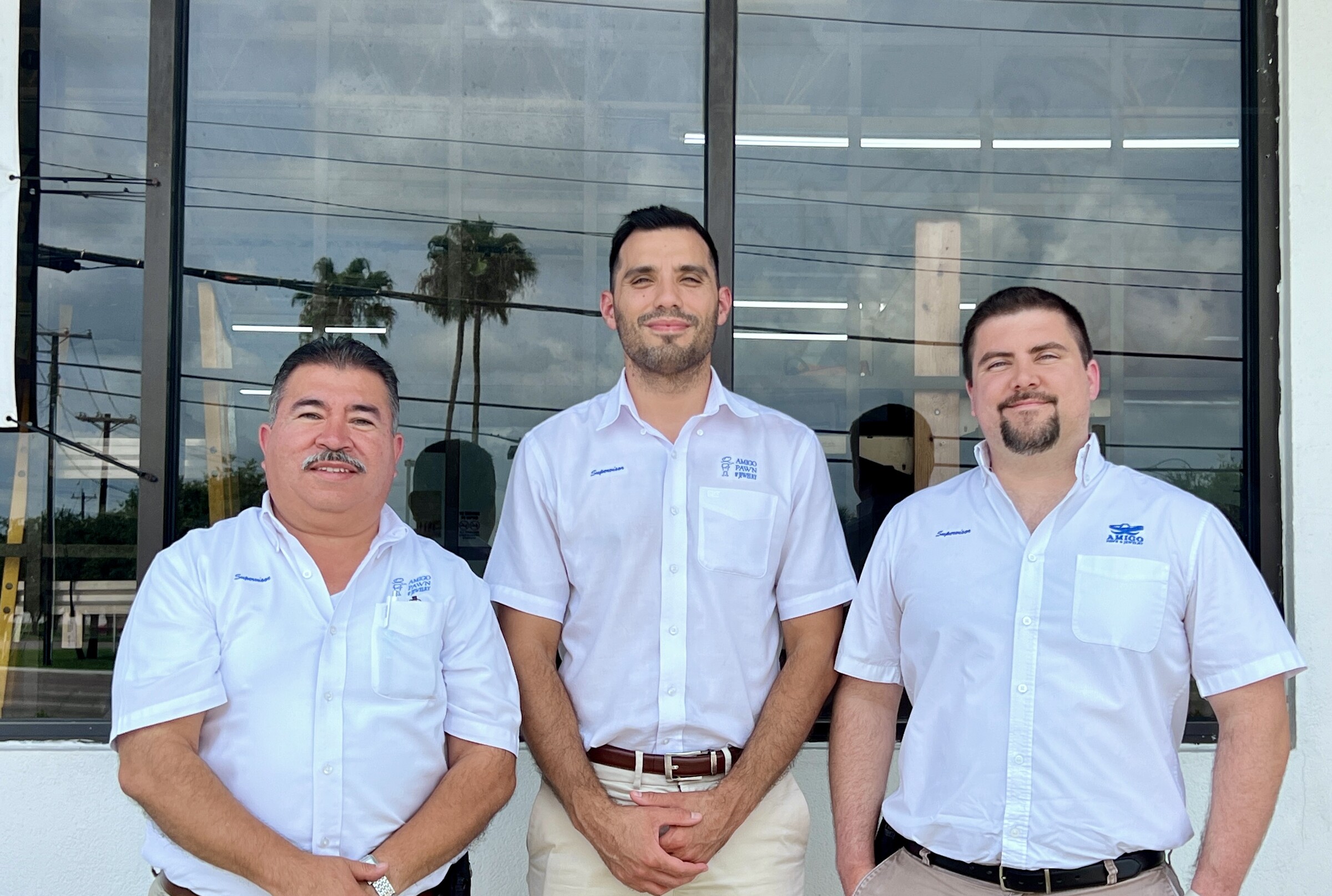 Three Amigo supervisors posing outside a store